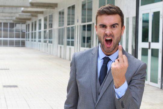 Moody businessman showing a middle finger