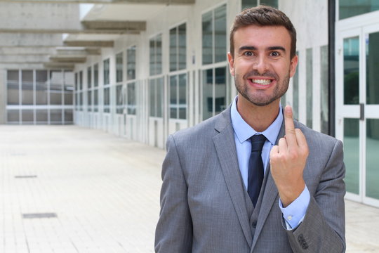 Moody businessman showing a middle finger