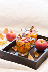 Hot spicy drink,tea with fruits and berrie on dark wooden tray. Autumn style photo.