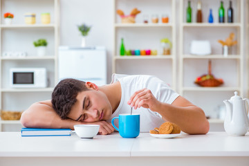 Obraz na płótnie Canvas Man falling asleep during his breakfast after overtime work