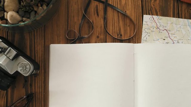 Close up top view on rustic wooden table and big a4 notebook with pure white recycled paper sheets turning over and over. Loop video of page turning of personal diary