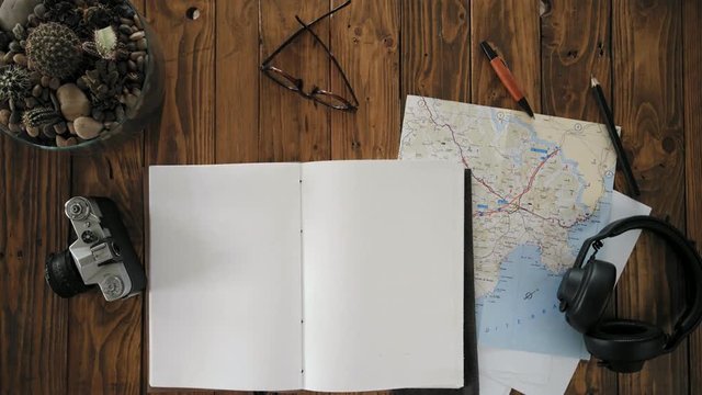 Top view on how manputsthick leather covered notebook or journal on artisan hipster wooden table, prepared for trip ideas, adventure planning, or business mindmap