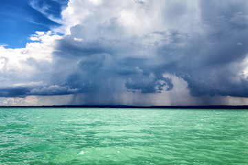 Obraz premium Clouds and rain over a beautiful turquoise lake