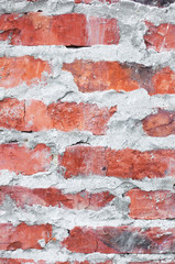 Texture of an old brick wall. Grunge red background of stone and cement. The shabby facade of the building with old bricks and damaged plaster. Abstract banner with copy space.