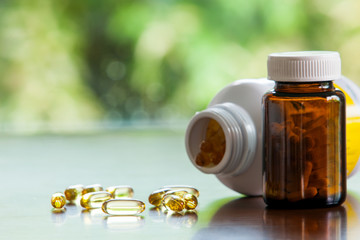 A Brown glass medicine bottle and Evening primrose oil capsule,supplementary food on table with...