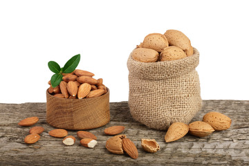 Almonds with leaf in bag from sacking on a wooden table with a white background