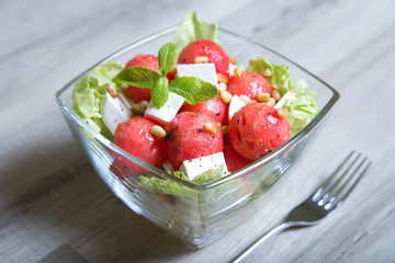 Salad with feta cheese, watermelon and pine nuts. Close-up. Selective focusing.