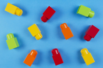 Colorful plastic construction blocks on blue background