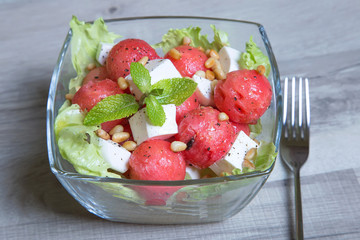 Salad with feta cheese, watermelon and pine nuts. Close-up. Selective focusing.