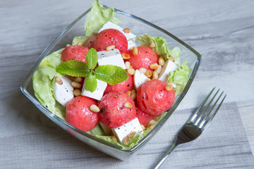 Salad with feta cheese, watermelon and pine nuts. Close-up. Selective focusing.