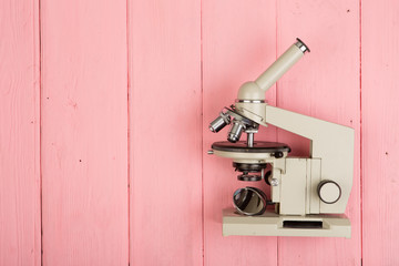 Microscope on pink wooden table