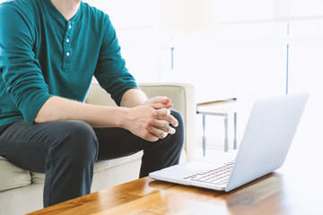 Man on a laptop in bright window lit room