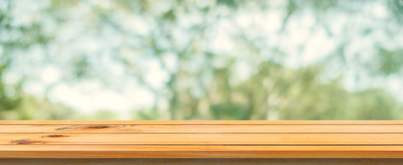 Wooden board empty table blurred background. Perspective brown wood table over blur trees forest background - can be used mock up for display or montage your products. spring season. panoramic banner.