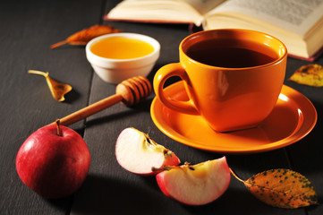 Autumn still life cup of tea, honey and book on the table