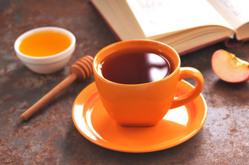 Autumn still life cup of tea, honey and book on the table