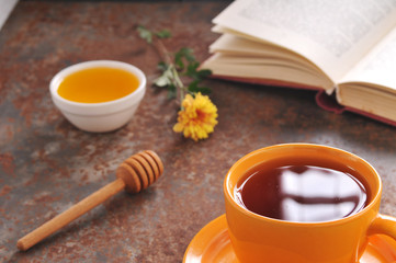 Autumn still life cup of tea, honey and book on the table