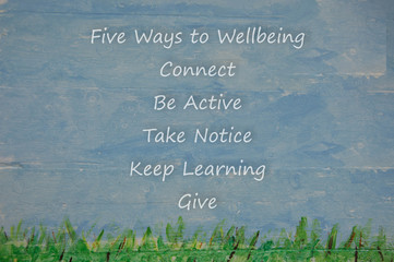 Five ways to wellbeing on blue ksy and grass wood background