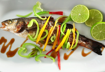 Serving plate with delicious fish in sauce and vegetables, closeup