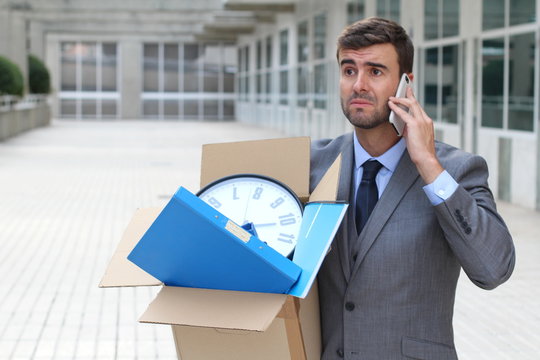Businessman having a dramatic moment on the phone after being fired