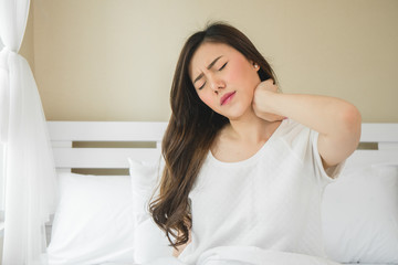 Asian woman have neckache in bedroom morning because sleep problem