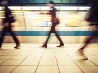 Subway train leaving station. People coming to or leaving the platform. Motion blur. City life.Toned image.