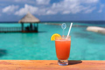 Fresh orange juice welcome drink at resort in maldive with background of beautiful ocean.