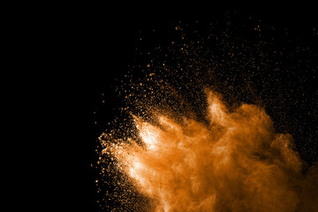 Explosion of orange dust on black background.