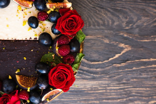 Half chocolate, half vanilla coconut cake, decorated with roses and fruits. Top view, copy space. Yin yang concept.