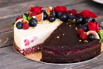 Two cakes in one, half chocolate, half vanilla coconut, decorated with roses and fruits. Dessert food photography. Yin yang concept.