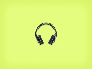 Black pair of headphones on green background