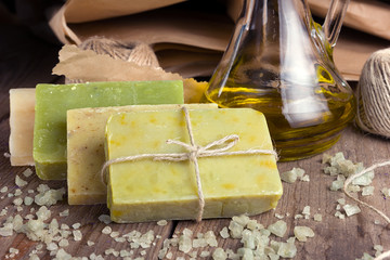 Collection of handmade, natural organic soap and cosmetic oil on wooden background. Spa products.