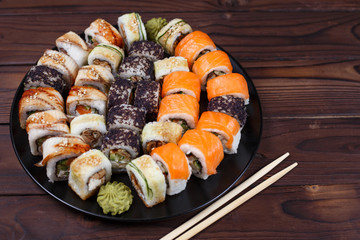 Colorful set of japanese sushi maki rolls with salmon, eel and caviar with chopsticks. Food art, traditional seafood, restaurant menu photo