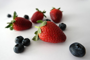 Fototapeta na wymiar Strawberries and blueberries on white background