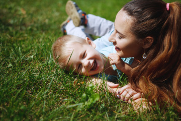 Young mother with little son having fun playing in the Park