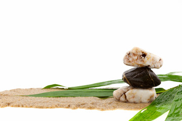 stack of stone and bamboo leaves on sand,white background.