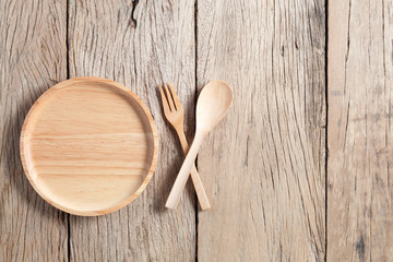 wooden spoon and wooden plate on old wood table background,copy space for your product and cooking design.