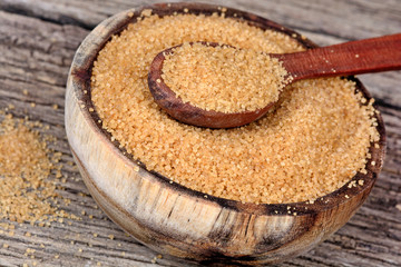 Brown sugar in a bowl and spoon on table