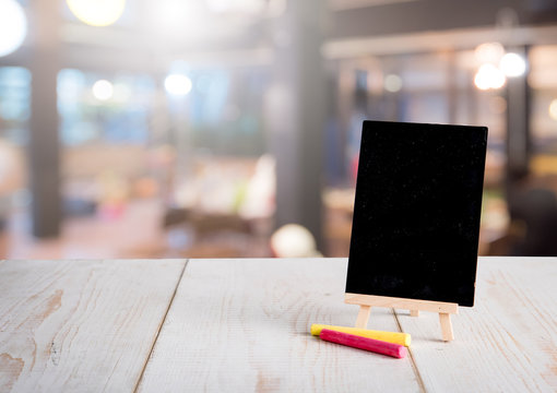 Blank restaurant blackboard on easel with blurred bokeh restaurant background,text space
