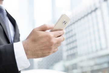 Business process photo. Account manager using mobile phone. Typing contemporary smartphone screen. 