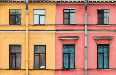 Several windows in a row on facades of two different apartment buildings adjacent tightly to each other front view, Saint Petersburg, Russia