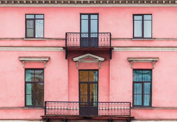 Several windows and balconies in a row on facade of urban apartment building front view, St. Petersburg, Russia