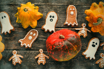 Funny delicious ginger biscuits for Halloween shape ghost and skeleton  with pumpkins and sweets. holiday text 