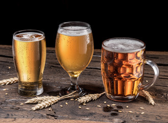 Different glasses of beer on the wooden table.