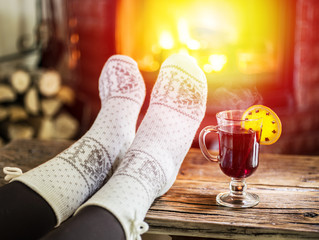 Warming and relaxing near fireplace with a cup of hot wine.