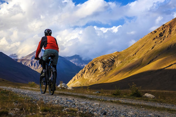 A man is riding a bicycle in the mountains. Autumn in the mountains.