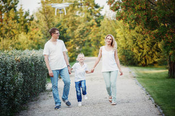 Obraz premium Happy young family walking on path in Park holding hands.