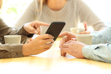 Three friends watching media in a smart phone