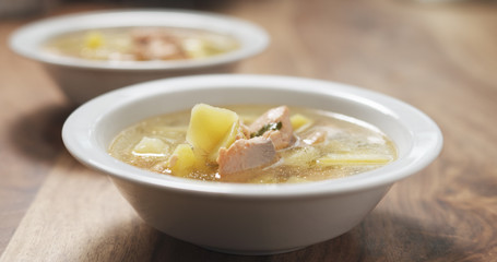 closeup fish soup with salmon on wood table