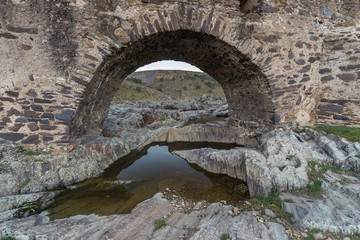 Fototapeta na wymiar Ancient Roman bridge over the Salor river, located near Aliseda. Extremadura. Spain.