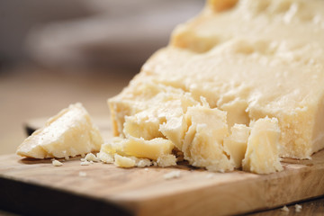 pieces of hard parmesan cheese on olive board